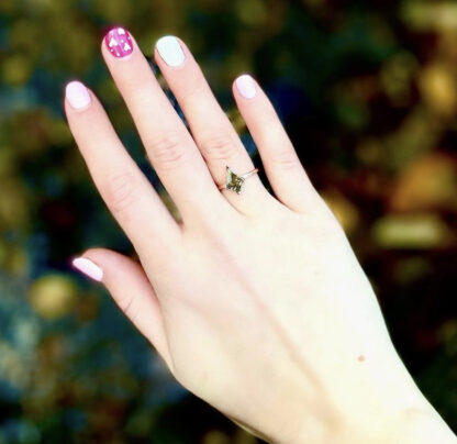 Kite shaped salt and pepper diamond ring on a hand.