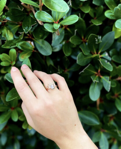 Salt and pepper ring on hand in front of greenery.