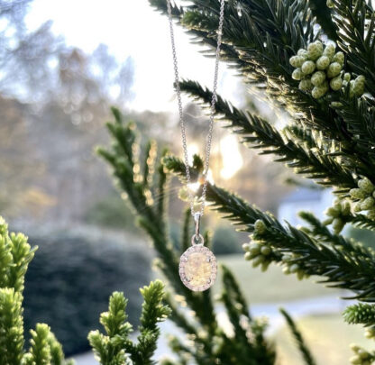 White salt and pepper necklace outside hanging on a tree.