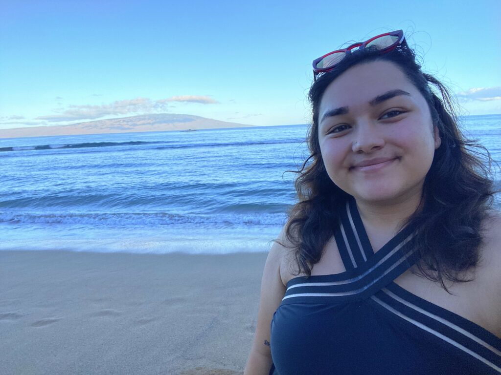 Selfie of me on the beach with an island in the background.